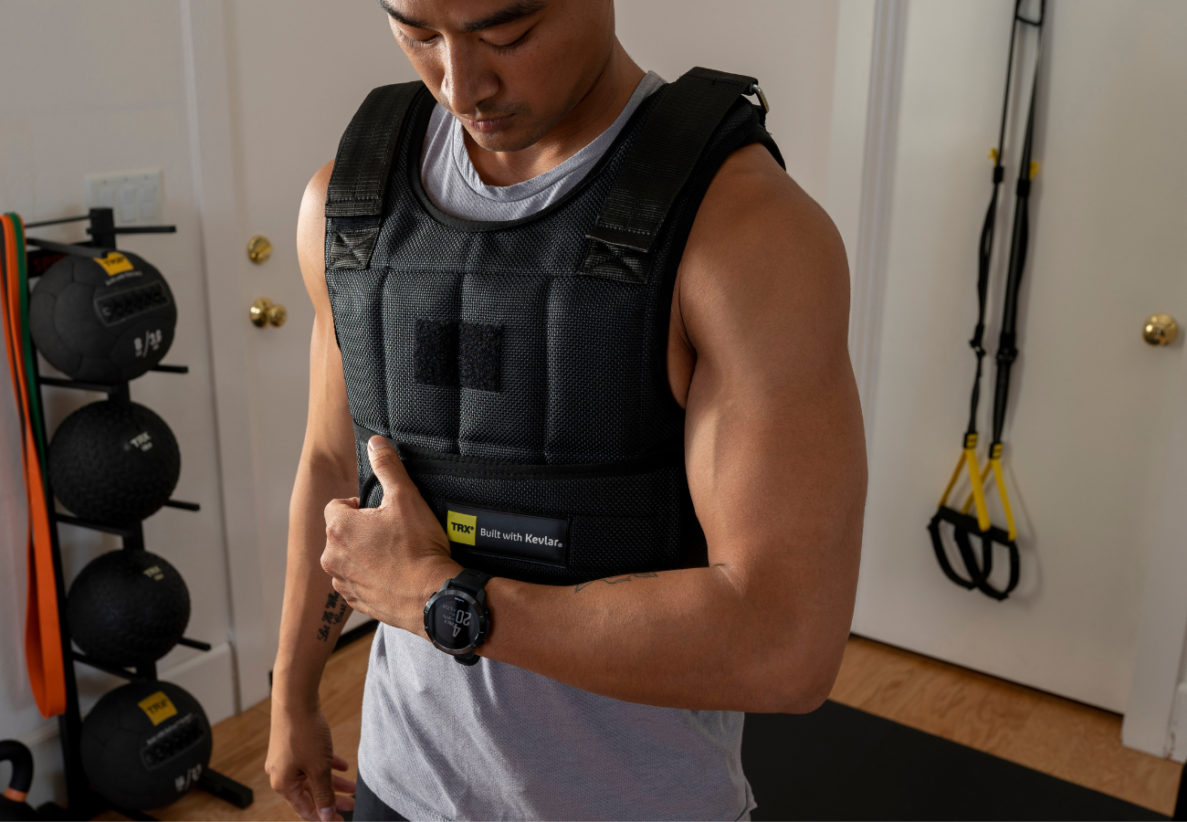 man putting on weight vest before workout